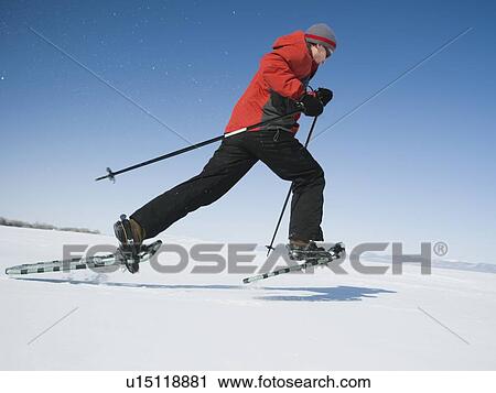 Stock Image - Man snow shoeing. Fotosearch