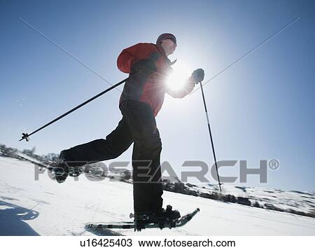 Stock Image - Man snow shoeing. Fotosearch