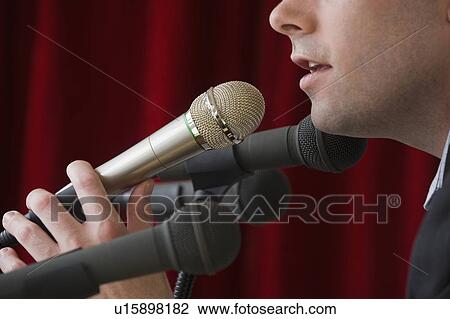Stock Image - Man speaking into microphone. Fotosearch