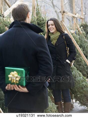 Man surprising girlfriend with gift View Large Photo Image Stock Image - Man surprising girlfriend with gift. Fotosearch