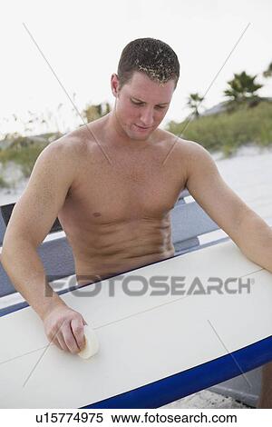 Man waxing surfboard View Large Photo Image Stock Photography - Man waxing surfboard. Fotosearch