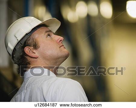 Man wearing hard hat and looking up View Large Photo Image Stock Photo - Man wearing hard hat and looking up. Fotosearch