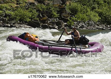 Stock Image - Man whitewater rafting. Fotosearch