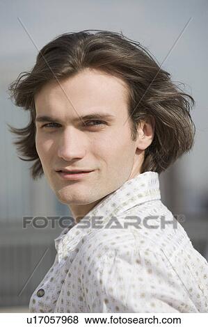 Man with hair blowing looking over shoulder View Large Photo Image Stock Photo - Man with hair blowing looking over shoulder. Fotosearch