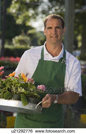 Stock Photograph - Man working in garden center. Fotosearch