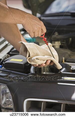 Mechanic checking oil View Large Photo Image Stock Photograph - Mechanic checking oil. Fotosearch