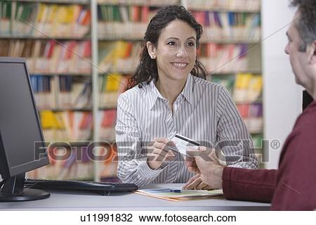 Medical receptionist accepting patient payment View Large Photo Image Stock Image - Medical receptionist accepting patient payment. Fotosearch