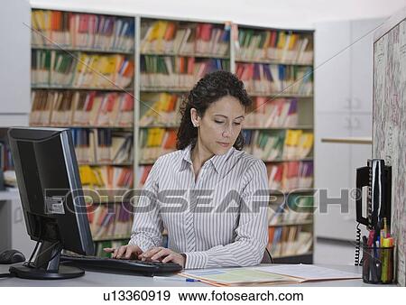 Medical receptionist reading chart View Large Photo Image Stock Photo - Medical receptionist reading chart. Fotosearch