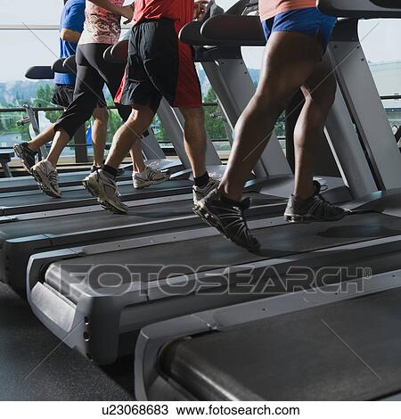 Stock Image - Men and woman running on treadmills. Fotosearch