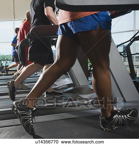 Stock Image - Men running on treadmills. Fotosearch