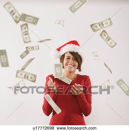 Money raining down on woman in Santa Claus hat View Large Photo Image Stock Photo - Money raining down on woman in Santa Claus hat. Fotosearch
