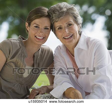 Picture - Mother and adult daughter posing outdoors. Fotosearch