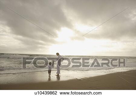 Mother and child holding hands at beach View Large Photo Image Stock Image - Mother and child holding hands at beach. Fotosearch