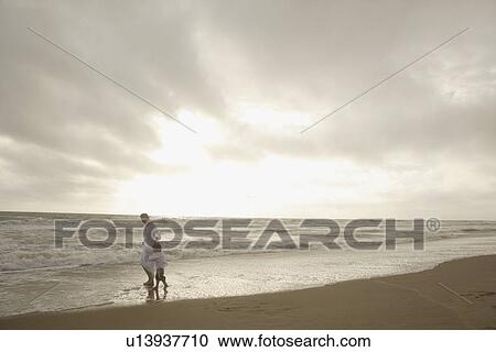 Mother and child walking on beach View Large Photo Image Stock Image - Mother and child walking on beach. Fotosearch