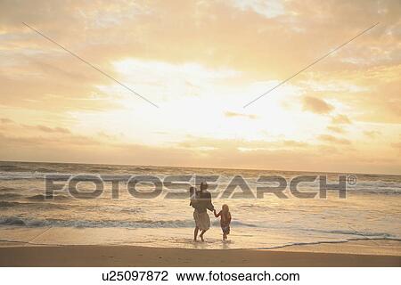 Mother and children walking on beach View Large Photo Image Stock Image - Mother and children walking on beach. Fotosearch