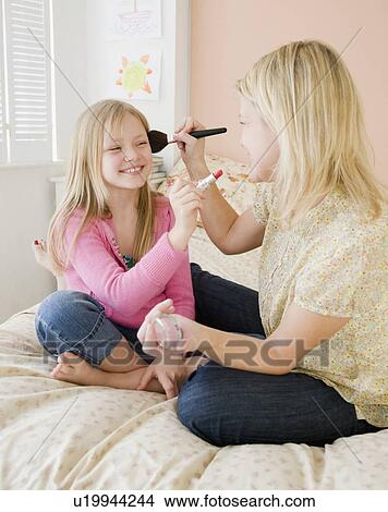 Picture - Mother and daughter applying makeup. Fotosearch