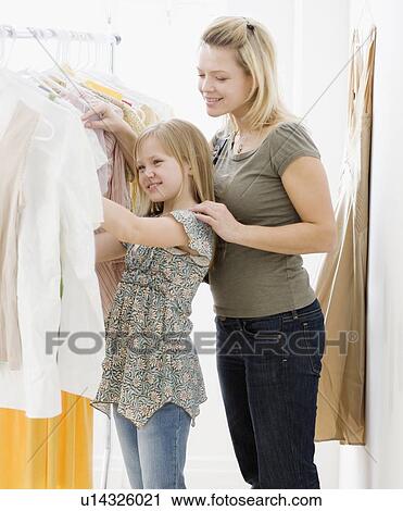 Stock Image - Mother and daughter clothing shopping. Fotosearch