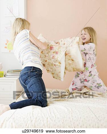 Mother and daughter having pillow fight View Large Photo Image Stock Photo - Mother and daughter having pillow fight. Fotosearch