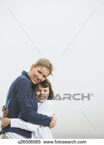 Stock Photography - Mother and daughter hugging on beach. Fotosearch