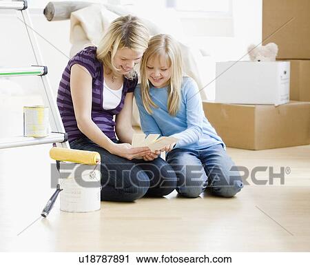 Stock Image - Mother and daughter looking at paint swatches. Fotosearch