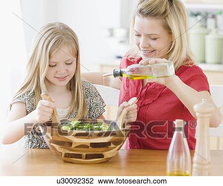Stock Image - Mother and daughter making salad. Fotosearch