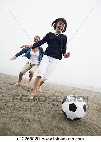 Mother and daughter playing soccer on beach View Large Photo Image Stock Image - Mother and daughter playing soccer on beach. Fotosearch