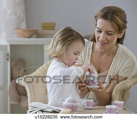 Stock Photography - Mother and daughter playing with tea set. Fotosearch