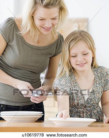 Mother and daughter setting table View Large Photo Image Stock Photo - Mother and daughter setting table. Fotosearch