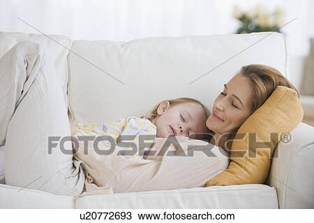 Stock Image - Mother and daughter sleeping on sofa. Fotosearch