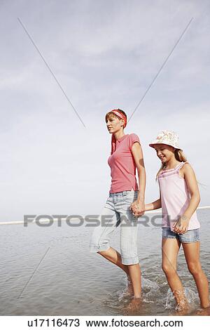 Mother and daughter walking in ocean View Large Photo Image Stock Image - Mother and daughter walking in ocean. Fotosearch