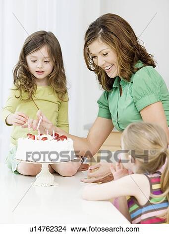 Mother and daughters decorating birthday cake View Large Photo Image Picture - Mother and daughters decorating birthday cake. Fotosearch