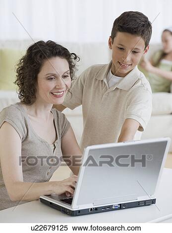 Stock Photography - Mother and son looking at laptop. Fotosearch