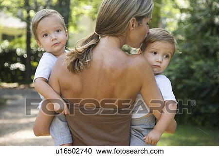 Mother carrying twin toddler sons View Large Photo Image Stock Image - Mother carrying twin toddler sons. Fotosearch