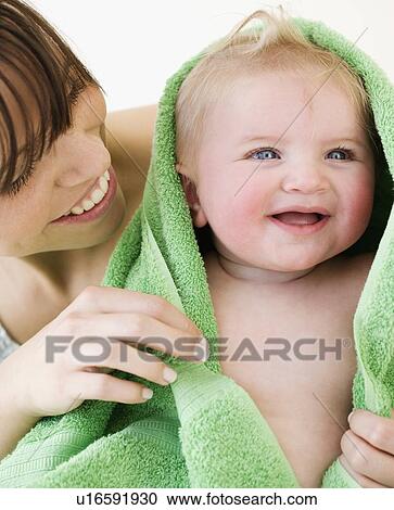 Stock Image - Mother drying baby with towel. Fotosearch