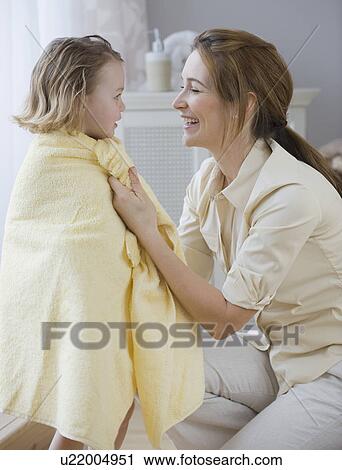Stock Image - Mother drying daughter with towel. Fotosearch