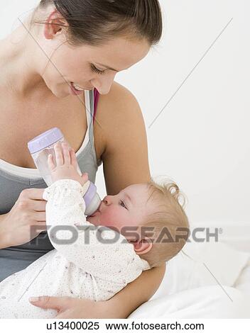 Mother feeding baby with bottle View Large Photo Image Stock Photography - Mother feeding baby with bottle. Fotosearch