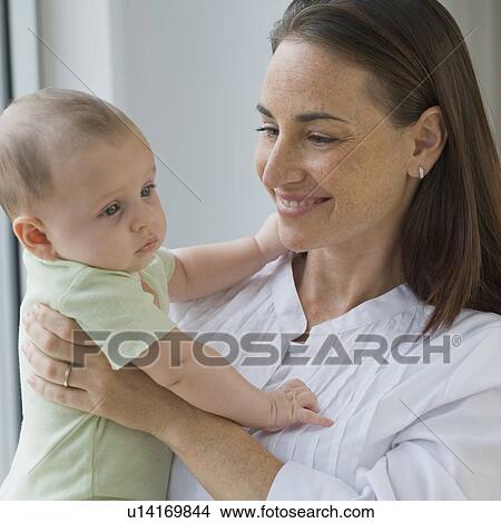 Picture - Mother holding baby son. Fotosearch
