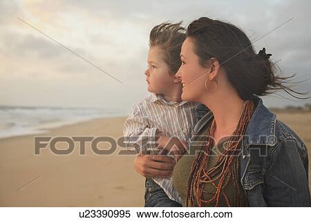 Stock Photography - Mother holding son at beach. Fotosearch