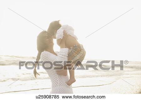 Mother holding son at beach View Large Photo Image Stock Photography - Mother holding son at beach. Fotosearch