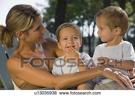 Stock Photo - Mother holding twin toddler sons. Fotosearch