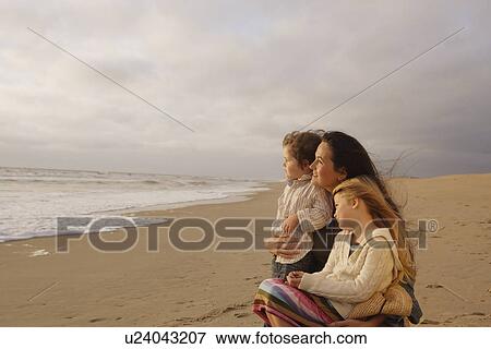 Stock Photo - Mother hugging children at beach. Fotosearch