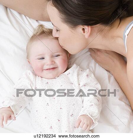 Mother kissing baby on head View Large Photo Image Picture - Mother kissing baby on head. Fotosearch