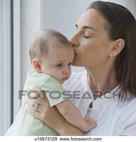 Stock Photo - Mother kissing baby son. Fotosearch