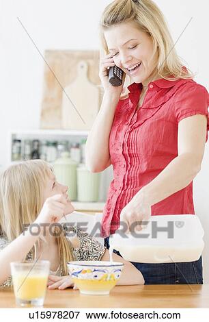 Mother pouring milk into daughter’s cereal View Large Photo Image Stock Photo - Mother pouring milk into daughter’s cereal. Fotosearch