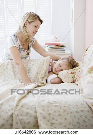 Stock Photograph - Mother watching daughter sleep. Fotosearch