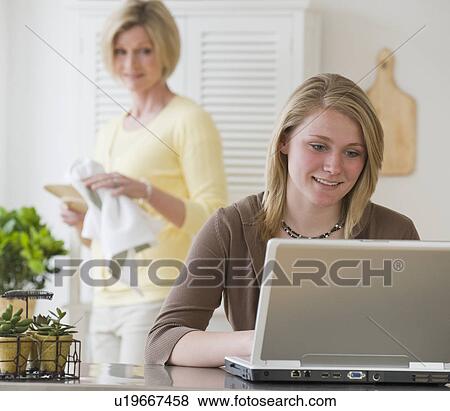 Mother watching teenaged daughter typing on computer View Large Photo Image Stock Photo - Mother watching teenaged daughter typing on computer. Fotosearch
