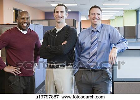 Multi-ethnic businessmen standing in office View Large Photo Image Stock Photo - Multi-ethnic businessmen standing in office. Fotosearch