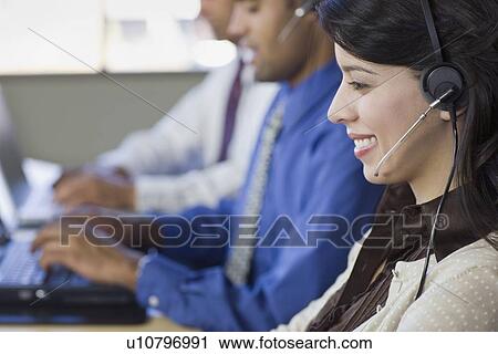 Stock Image - Multi-ethnic businesspeople wearing headsets. Fotosearch