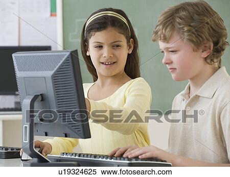 Stock Photography - Multi-ethnic school children looking at computers. Fotosearch