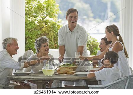 Picture - Multi-generational family eating on porch. Fotosearch